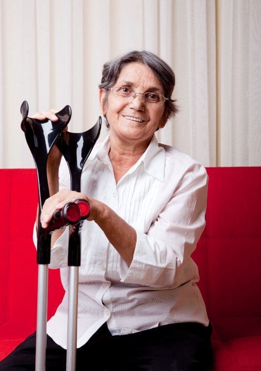 elderly lady sitting with crutches